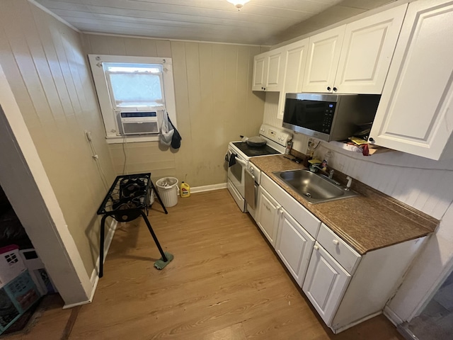628 W 7th St, Riviera Beach, FL 33404 - kitchen featuring white range with electric cooktop, stainless steel microwave, cooling unit, white cabinetry, and light wood-type flooring
