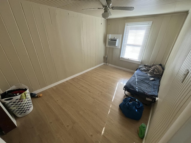 628 W 7th St, Riviera Beach, FL 33404 - unfurnished bedroom featuring wood finished floors, an AC wall unit, a ceiling fan, and wood walls