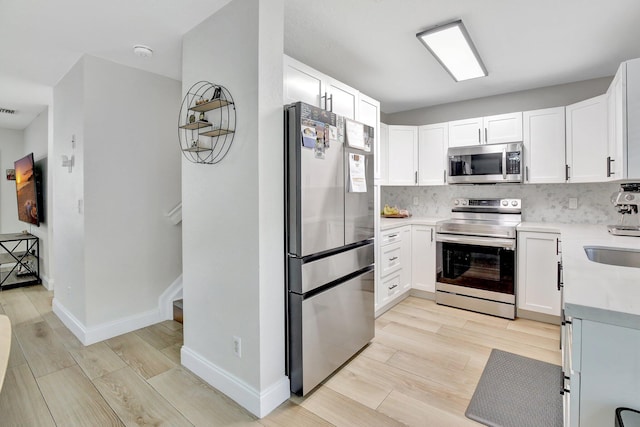 8730 SW 21st St, Miramar, FL 33025 - kitchen featuring stainless steel appliances, light wood-style flooring, light countertops, and tasteful backsplash