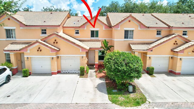 8730 SW 21st St, Miramar, FL 33025 - view of property featuring driveway, an attached garage, and stucco siding
