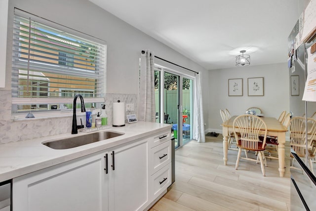 8730 SW 21st St, Miramar, FL 33025 - kitchen featuring tasteful backsplash, white cabinets, and light wood-style floors