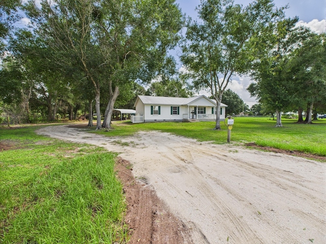 7281 NW 90th Ct, Okeechobee, FL 34972 - view of front of house featuring driveway, a front lawn, and a carport