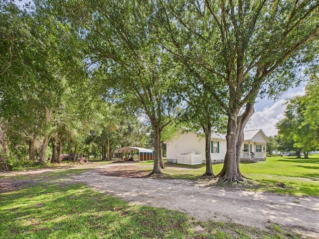 7281 NW 90th Ct, Okeechobee, FL 34972 - view of front of house featuring a carport, driveway, and a front lawn