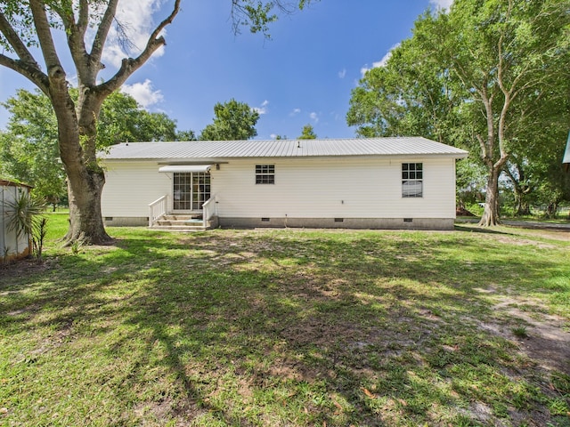 7281 NW 90th Ct, Okeechobee, FL 34972 - back of property featuring crawl space, a lawn, and a metal roof