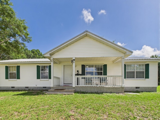 7281 NW 90th Ct, Okeechobee, FL 34972 - view of front of property with crawl space, covered porch, a front yard, and a metal roof