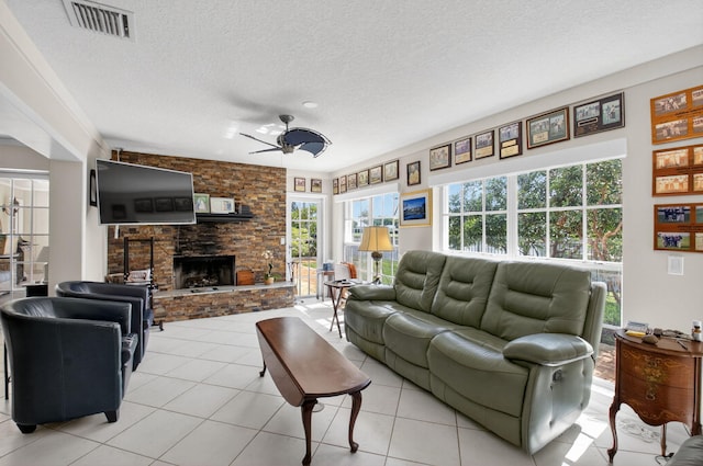 11814 N Lake Dr, Boynton Beach, FL 33436 - living area with a ceiling fan, healthy amount of natural light, a stone fireplace, a textured ceiling, and light tile patterned floors