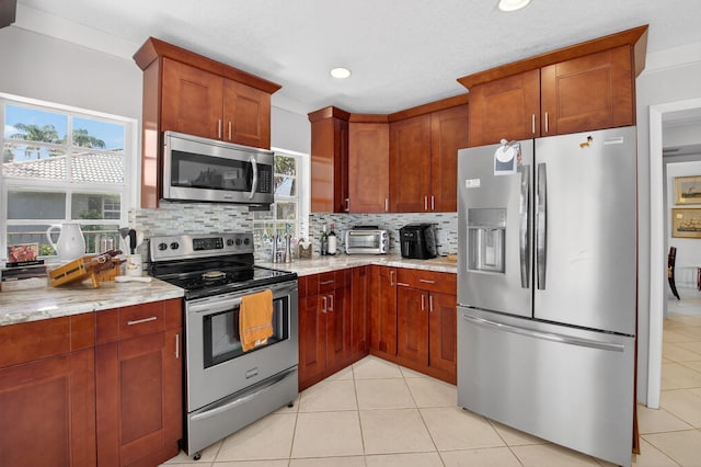 11814 N Lake Dr, Boynton Beach, FL 33436 - kitchen featuring appliances with stainless steel finishes, tasteful backsplash, light tile patterned floors, light stone countertops, and recessed lighting