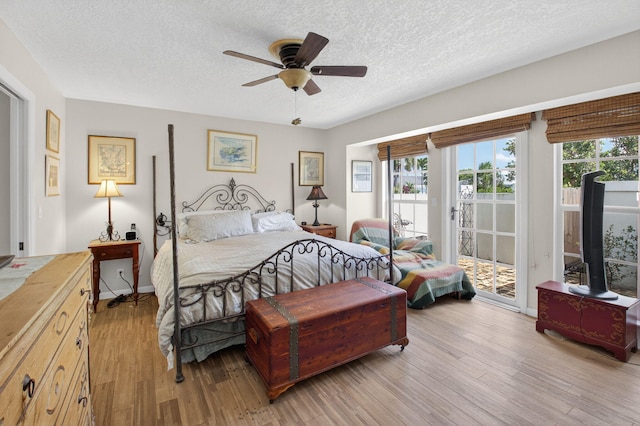 11814 N Lake Dr, Boynton Beach, FL 33436 - bedroom with access to exterior, multiple windows, light wood-type flooring, a textured ceiling, and a ceiling fan