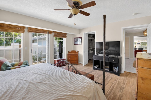 11814 N Lake Dr, Boynton Beach, FL 33436 - bedroom featuring access to outside, light wood-style flooring, a textured ceiling, and a ceiling fan