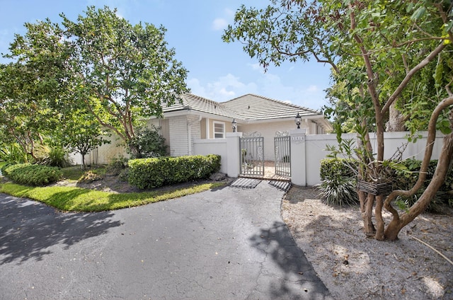 11814 N Lake Dr, Boynton Beach, FL 33436 - view of front facade with a gate, a fenced front yard, brick siding, and a tile roof