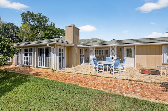 11814 N Lake Dr, Boynton Beach, FL 33436 - rear view of property featuring a chimney, a patio, and a yard