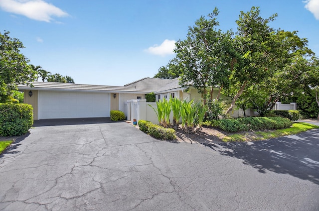 11814 N Lake Dr, Boynton Beach, FL 33436 - view of front of property featuring asphalt driveway, a garage, a tiled roof, and stucco siding