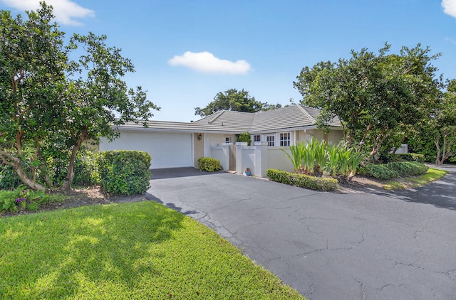 11814 N Lake Dr, Boynton Beach, FL 33436 - ranch-style home with a garage, driveway, stucco siding, and a tiled roof