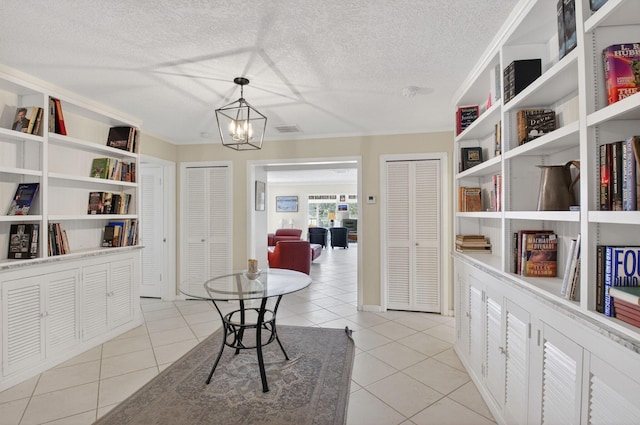 11814 N Lake Dr, Boynton Beach, FL 33436 - dining space featuring light tile patterned flooring, a chandelier, a textured ceiling, and ornamental molding