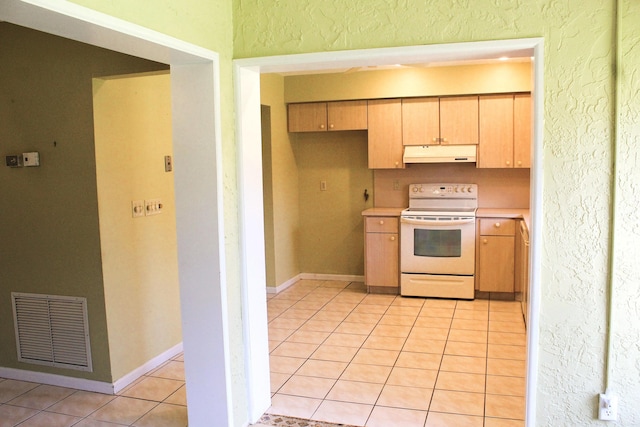 4660 Finchwood Ter Unit B, Boynton Beach, FL 33436 - kitchen featuring electric range, under cabinet range hood, light tile patterned flooring, light countertops, and a textured wall