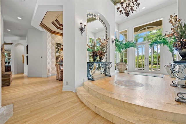 8571 Egret Lakes Ln, West Palm Beach, FL 33412 - entryway with arched walkways, wood finished floors, a chandelier, recessed lighting, and french doors