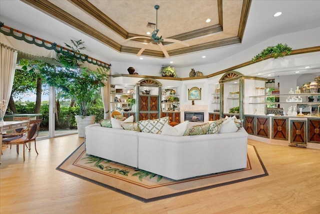 8571 Egret Lakes Ln, West Palm Beach, FL 33412 - living area featuring ceiling fan, crown molding, wood finished floors, a glass covered fireplace, and a raised ceiling
