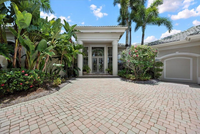 8571 Egret Lakes Ln, West Palm Beach, FL 33412 - doorway to property with french doors, a tile roof, decorative driveway, and a garage
