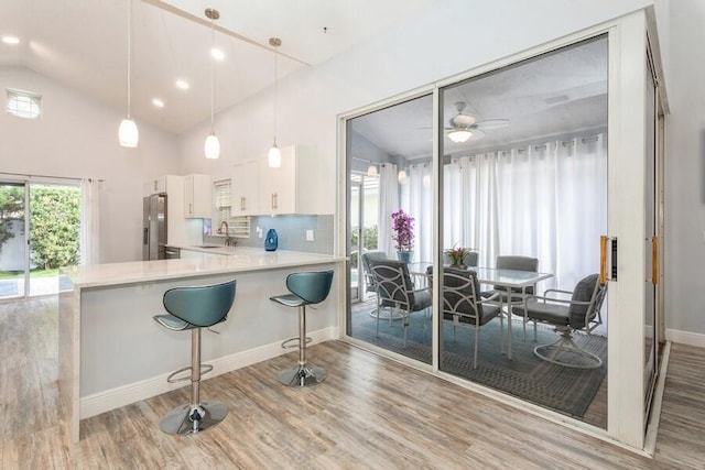 10 Hampton Ct, Palm Beach Gardens, FL 33418 - kitchen with freestanding refrigerator, white cabinetry, light countertops, wood finished floors, and a ceiling fan