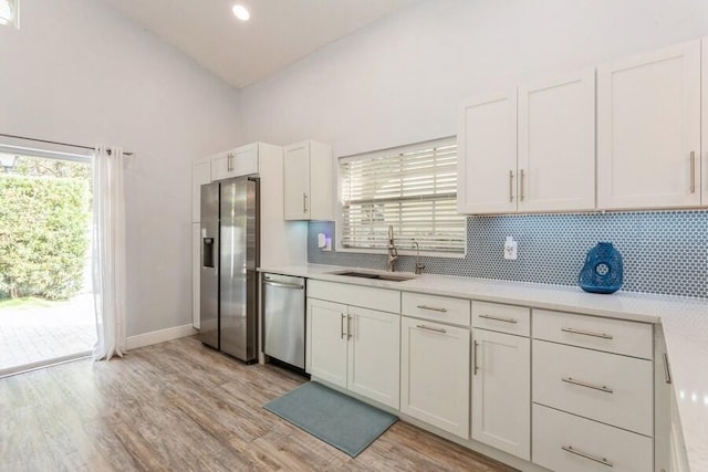 10 Hampton Ct, Palm Beach Gardens, FL 33418 - kitchen with appliances with stainless steel finishes, light countertops, decorative backsplash, high vaulted ceiling, and white cabinetry