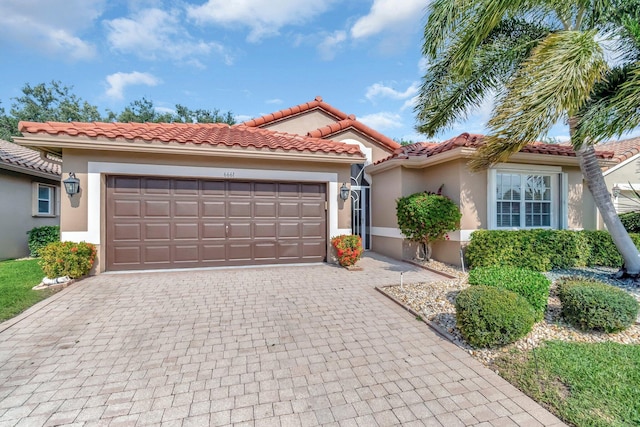 6661 Sherbrook Dr, Boynton Beach, FL 33437 - mediterranean / spanish-style home featuring decorative driveway, stucco siding, an attached garage, and a tiled roof
