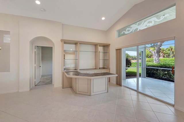 6661 Sherbrook Dr, Boynton Beach, FL 33437 - kitchen featuring a peninsula, arched walkways, high vaulted ceiling, light tile patterned floors, and recessed lighting
