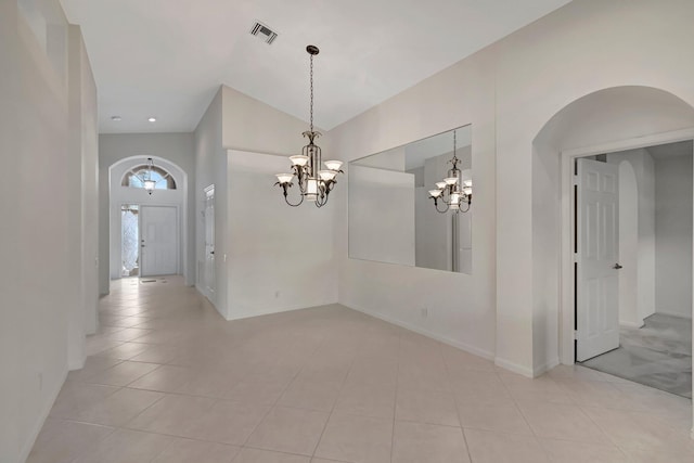 6661 Sherbrook Dr, Boynton Beach, FL 33437 - spare room with arched walkways, a chandelier, light tile patterned floors, and lofted ceiling