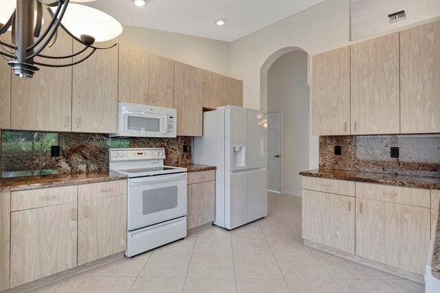6661 Sherbrook Dr, Boynton Beach, FL 33437 - kitchen featuring white appliances, light brown cabinets, dark stone counters, arched walkways, and backsplash