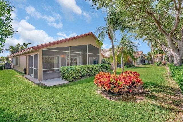 6661 Sherbrook Dr, Boynton Beach, FL 33437 - back of house with a tiled roof, a sunroom, a lawn, and stucco siding