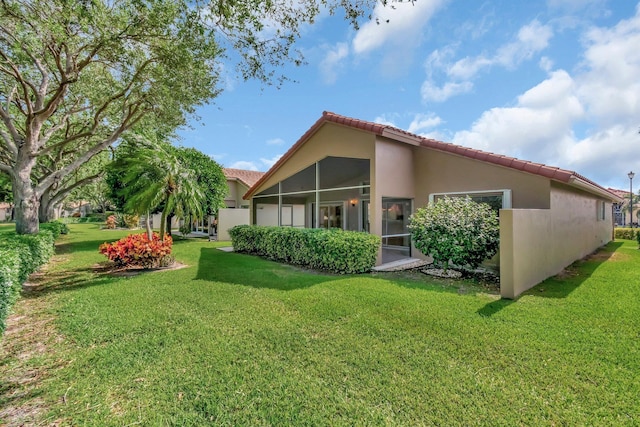 6661 Sherbrook Dr, Boynton Beach, FL 33437 - back of property with stucco siding, a tiled roof, a sunroom, and a yard