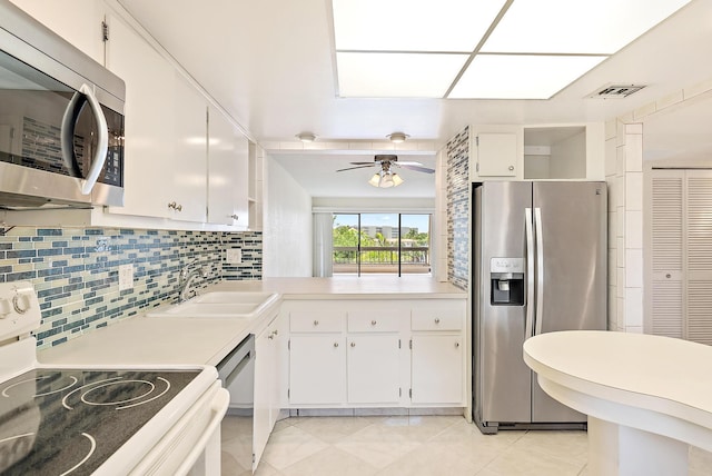 1036 US Highway 1 Unit 318, North Palm Beach, FL 33408 - kitchen with stainless steel appliances, white cabinets, light countertops, and tasteful backsplash