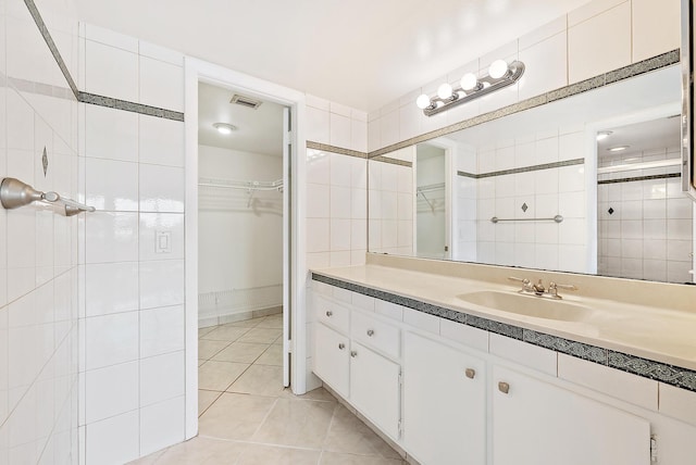 1036 US Highway 1 Unit 318, North Palm Beach, FL 33408 - bathroom with a spacious closet, tile patterned flooring, vanity, and tiled shower