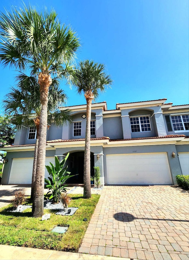 2247 SW Cape Cod Dr, Port Saint Lucie, FL 34953 - view of front facade featuring stucco siding, decorative driveway, and an attached garage
