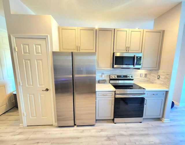 2247 SW Cape Cod Dr, Port Saint Lucie, FL 34953 - kitchen with appliances with stainless steel finishes, light countertops, and light wood finished floors