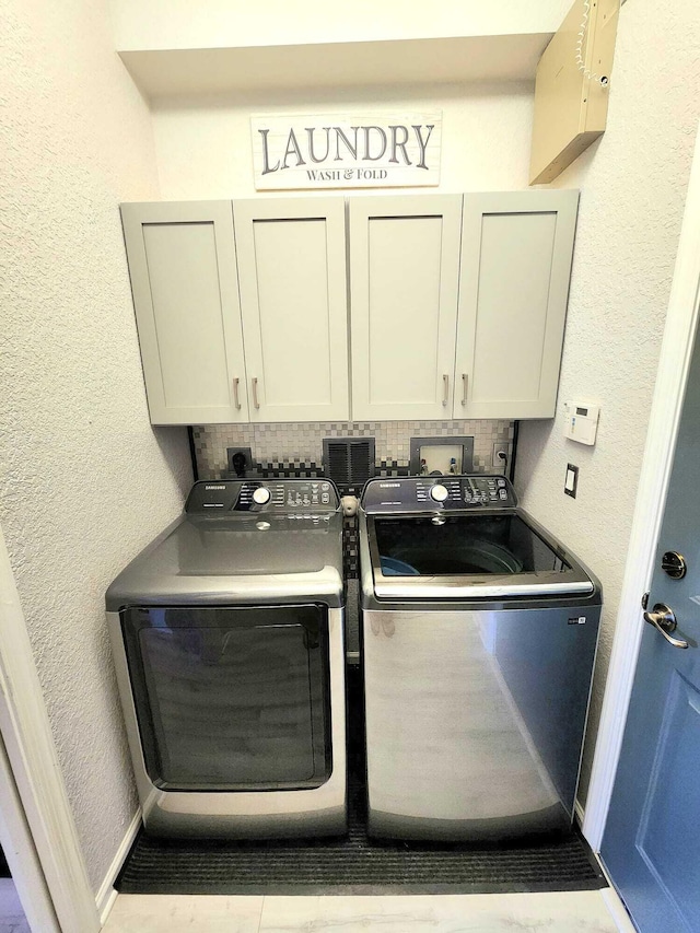 2247 SW Cape Cod Dr, Port Saint Lucie, FL 34953 - laundry area with cabinet space, washing machine and dryer, and a textured wall