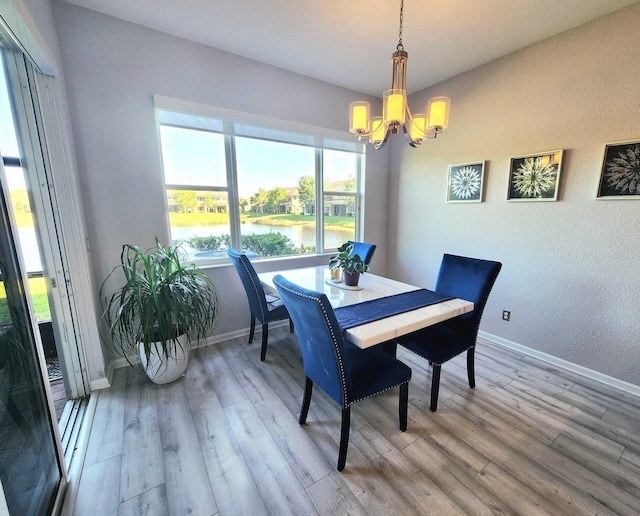 2247 SW Cape Cod Dr, Port Saint Lucie, FL 34953 - dining area with a chandelier, a water view, and light wood-style floors