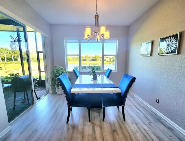 2247 SW Cape Cod Dr, Port Saint Lucie, FL 34953 - dining space featuring a textured wall, a chandelier, wood finished floors, and a water view
