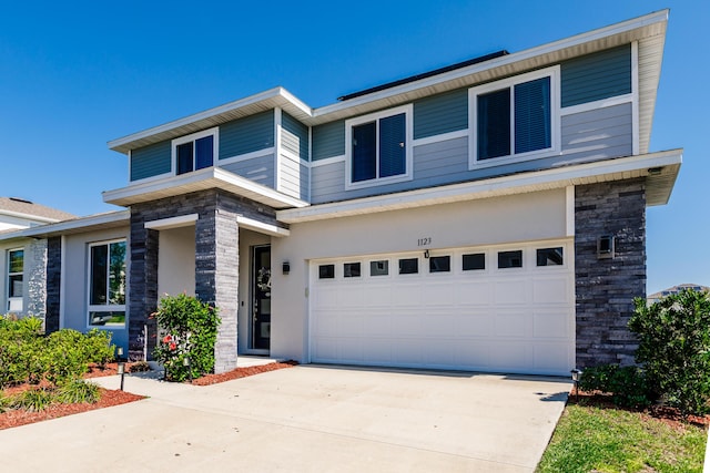 1123 Sugarwood St, Davenport, FL 33837 - view of front of home featuring stone siding, an attached garage, and driveway