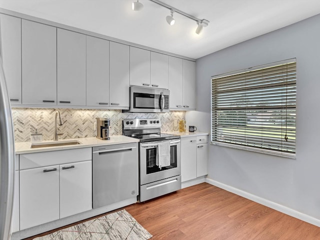 9199 Pecky Cypress Ln Unit 7H, Boca Raton, FL 33428 - kitchen with stainless steel appliances, rail lighting, light countertops, and backsplash