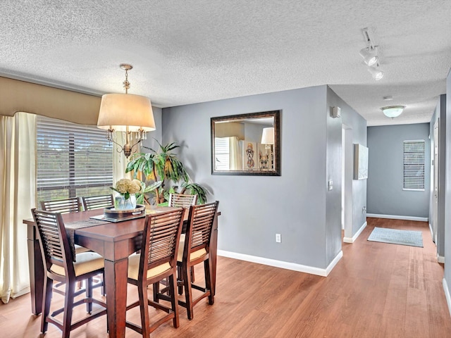 9199 Pecky Cypress Ln Unit 7H, Boca Raton, FL 33428 - dining space with a textured ceiling, wood finished floors, and a chandelier