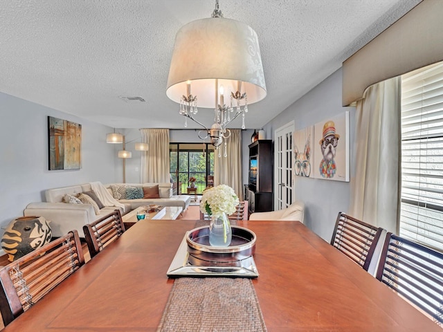 9199 Pecky Cypress Ln Unit 7H, Boca Raton, FL 33428 - dining room featuring a textured ceiling and a chandelier