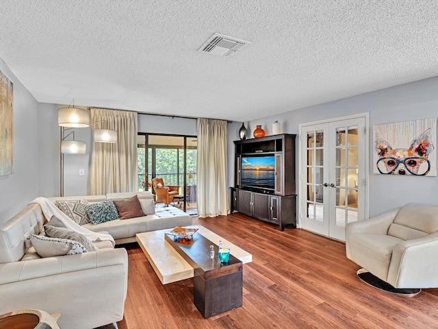 9199 Pecky Cypress Ln Unit 7H, Boca Raton, FL 33428 - living room with french doors, dark wood-style floors, and a textured ceiling