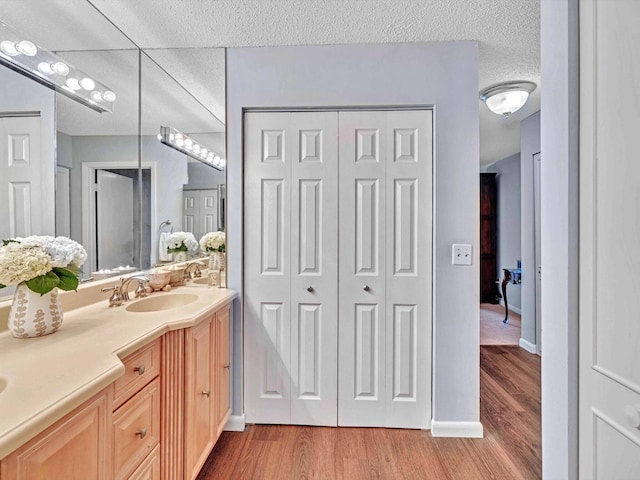 9199 Pecky Cypress Ln Unit 7H, Boca Raton, FL 33428 - full bath featuring a closet, double vanity, wood finished floors, and a textured ceiling