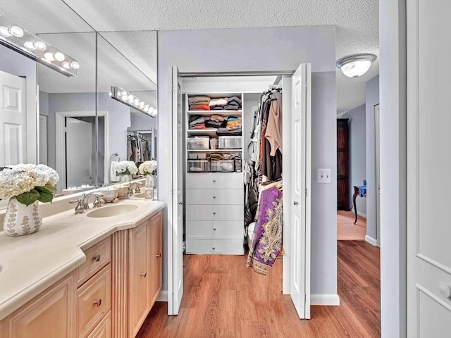 9199 Pecky Cypress Ln Unit 7H, Boca Raton, FL 33428 - full bathroom with wood finished floors, vanity, a walk in closet, and a textured ceiling