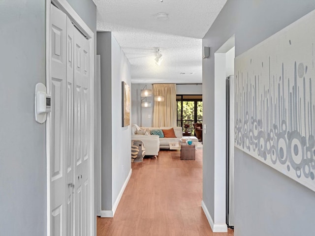 9199 Pecky Cypress Ln Unit 7H, Boca Raton, FL 33428 - hall with light wood-style floors and a textured ceiling