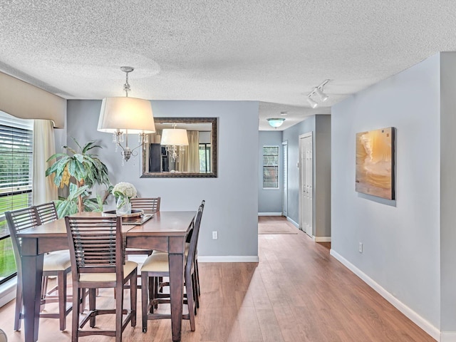 9199 Pecky Cypress Ln Unit 7H, Boca Raton, FL 33428 - dining space featuring wood finished floors, a textured ceiling, and track lighting