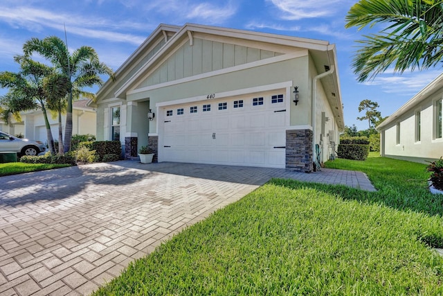 440 SE Mulberry Way, Port Saint Lucie, FL 34984 - view of front of home with stone siding, an attached garage, decorative driveway, and a front lawn