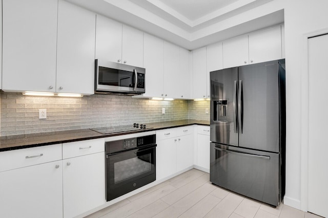 120 Ocean Grande Blvd Unit 302, Jupiter, FL 33477 - kitchen featuring black appliances, dark countertops, white cabinetry, and backsplash