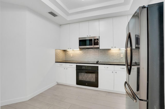 120 Ocean Grande Blvd Unit 302, Jupiter, FL 33477 - kitchen with black appliances, dark countertops, tasteful backsplash, and a raised ceiling