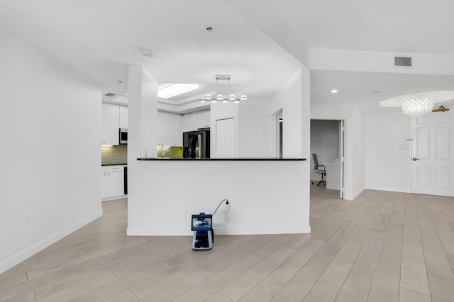 120 Ocean Grande Blvd Unit 302, Jupiter, FL 33477 - kitchen featuring freestanding refrigerator, white cabinets, dark countertops, decorative backsplash, and stainless steel microwave